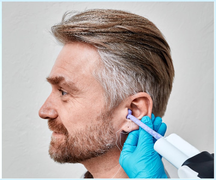 Man getting custom earmolds from his audiologist