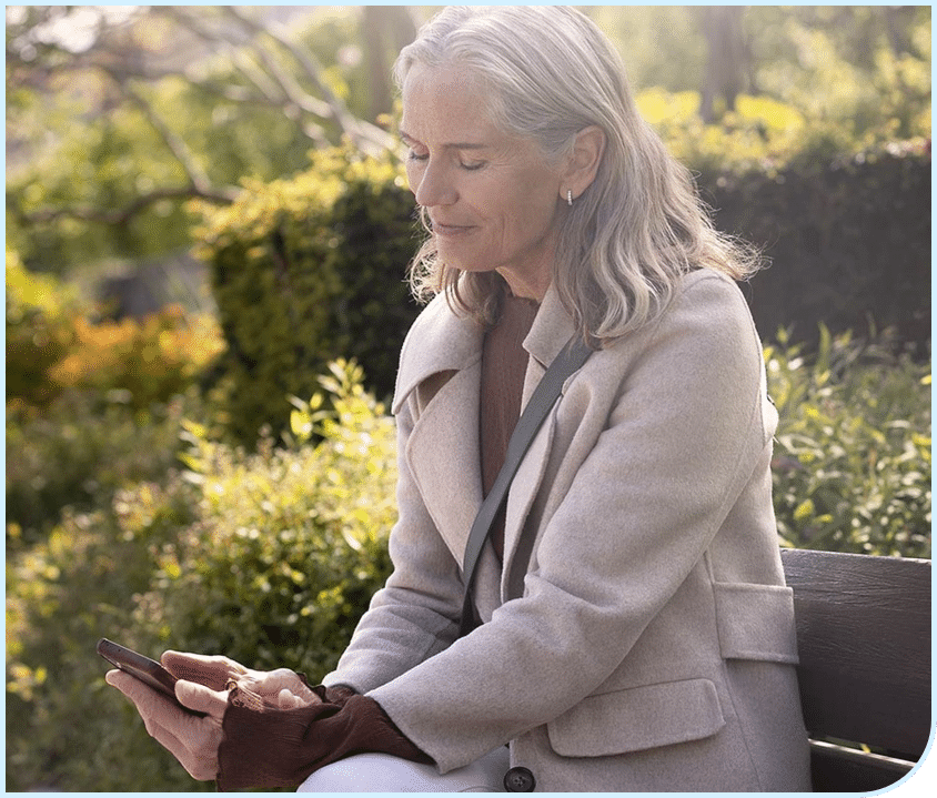 Woman on her phone with her Widex hearing aids connected